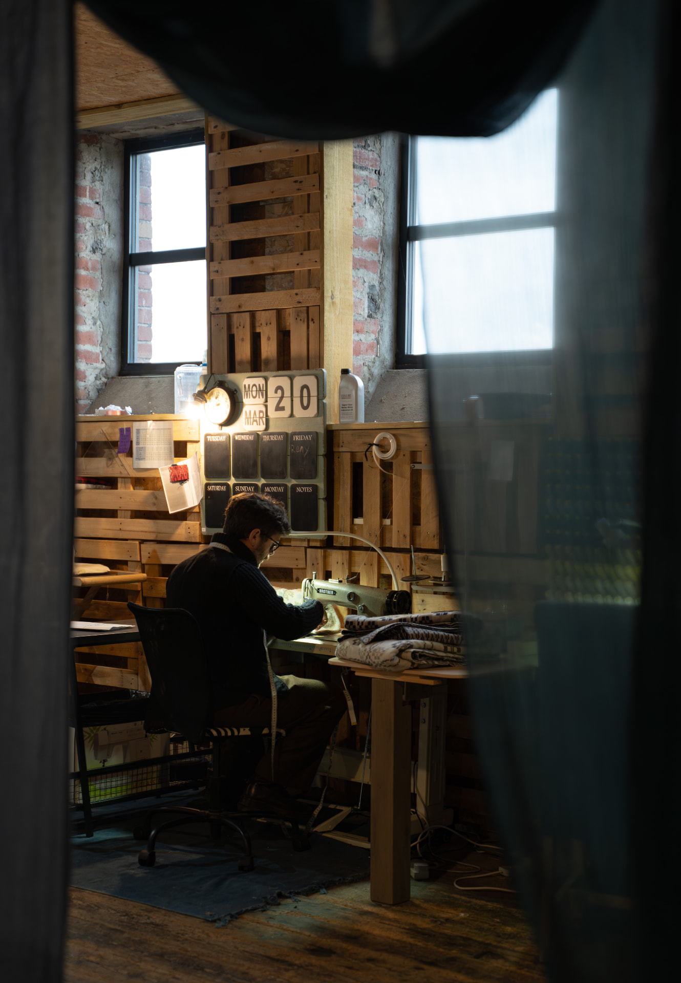 Maker working at a sewing machine in a wooden workshop